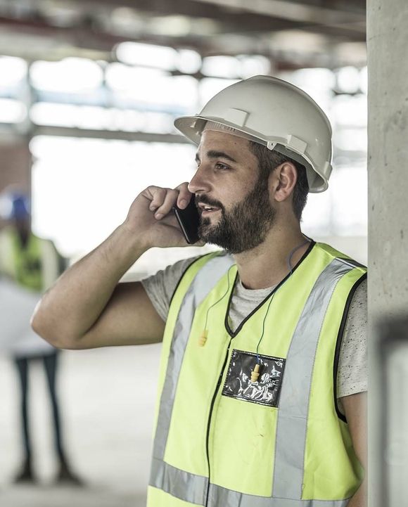 Construction worker talking on the phone at the construction site